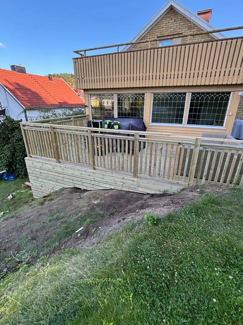 Ny altan med räcke på sluttande tomt