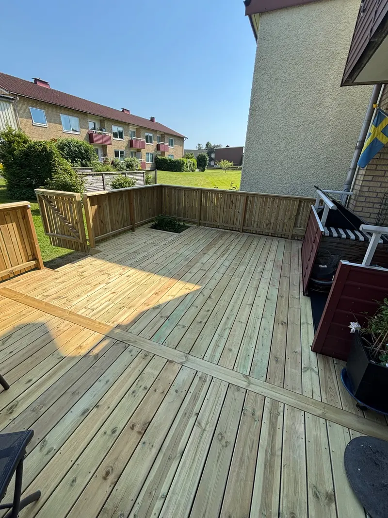 Stor ny trallaltan med plank runt kanten intill tegelfasad